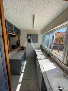 a large kitchen with a sink and a window at Joli appartement avec grande et belle terrasse, au pied de la plage du Grazel! in Gruissan