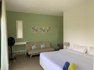 a bedroom with a white bed and a chair at Azuri Apartment 8 in Roches Noires