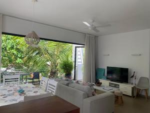 a living room with a couch and a table and a tv at Azuri Apartment 8 in Roches Noires