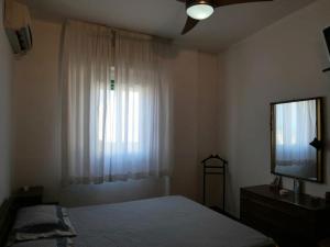 um quarto com uma cama, uma janela e uma televisão em 100 passi dal mare em Isola delle Femmine