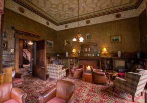 a living room filled with furniture and a fire place at Macdonald Norwood Hall Hotel in Aberdeen