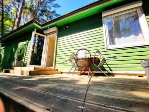 a green house with two chairs on a porch at G3 in Palanga +14 photos