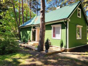 a green house with a tree in front of it at G3 in Palanga