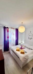 a bedroom with a large bed with purple curtains at La suite de Mathilde Disneyland Paris in Montévrain