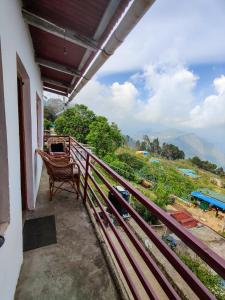 a balcony with a chair and a view of a mountain at Venish Home Stay in Kodaikānāl