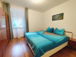 a bedroom with a bed with blue sheets and a window at Apartment Ane in Dramalj