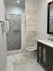 a bathroom with a shower, toilet, sink and tub at Lafitte Hotel & Bar in New Orleans