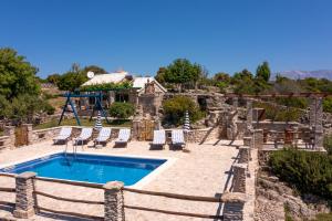 a pool in a yard with chairs and a house at The Ultimate Escape - traditional cottage & private pool in Selca