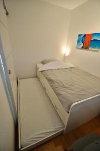 1 cama en una habitación pequeña con un cuadro en la pared en Strandperle, en Friedrichskoog