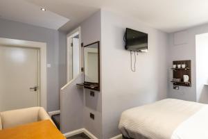 a bedroom with a bed and a mirror and a table at Bugler Doyles Bar & Townhouse in Wexford
