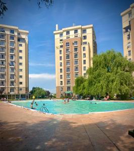 pessoas numa piscina com dois edifícios altos em Forever Friday Apartment Cosmopolis em Creţuleasca