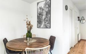 a dining room table with chairs and a vase on it at Cozy Home In Heinkenszand With Kitchen in Heinkensand