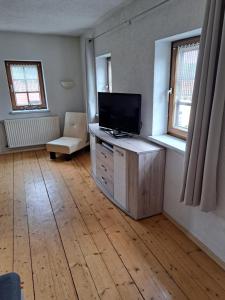 una sala de estar con TV de pantalla plana en un armario de madera en Ferienhaus Gesindestube Trusetal, en Brotterode