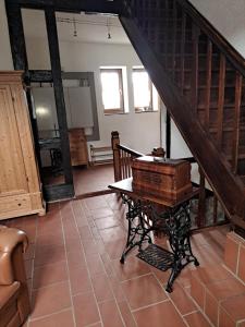 Habitación con mesa de madera y escalera. en Ferienhaus Gesindestube Trusetal, en Brotterode