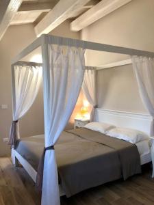 a bedroom with a canopy bed with white curtains at b&b Tenuta il Molino in Quercianella