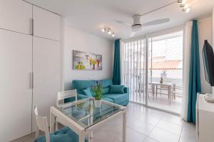 salon z niebieską kanapą i szklanym stołem w obiekcie LA SIESTA APARTMENT w mieście Costa Del Silencio