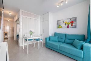 salon z niebieską kanapą i stołem w obiekcie LA SIESTA APARTMENT w mieście Costa Del Silencio