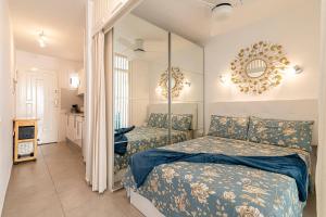 sypialnia z 2 łóżkami i lustrem na ścianie w obiekcie LA SIESTA APARTMENT w mieście Costa Del Silencio