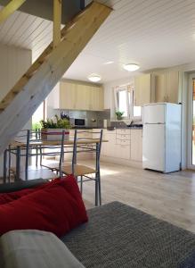 a kitchen with a table and a white refrigerator at AGA Domek na Kaszubach in Sławki