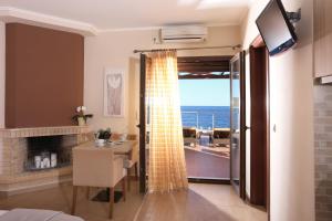 Sala de estar con mesa y vistas al océano en Faros Luxury Suites en Marathopoli