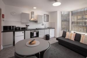 a kitchen and living room with a table and a couch at Jellyfish Apartments in Blackpool