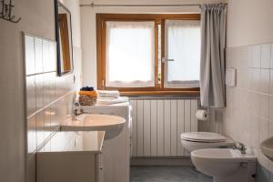 a bathroom with a sink and a toilet and a window at Italian Vacation Homes - Longol in Riva di Solto