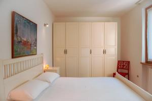 a bedroom with a white bed and a red chair at Italian Vacation Homes - Longol in Riva di Solto