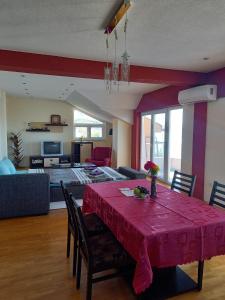 a living room with a table with a red table cloth at PS Apartments - Peshtani in Peštani