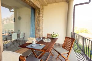 a wooden table and chairs on a balcony at Italian Vacation Homes - Longol in Riva di Solto