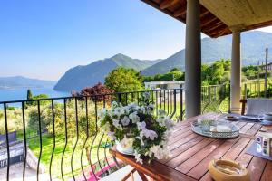 a wooden table with a vase of flowers on a balcony at Italian Vacation Homes - Longol in Riva di Solto