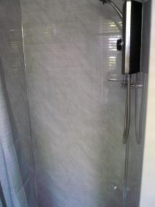 a shower with a glass door in a bathroom at Woodburn ground-floor apartment in quiet setting in Pitlochry in Pitlochry