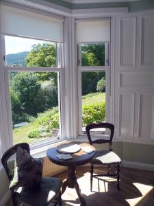 a room with two chairs and a table in front of a window at Woodburn ground-floor apartment in quiet setting in Pitlochry in Pitlochry
