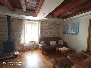 ein Wohnzimmer mit einem Sofa und einem Tisch in der Unterkunft Apartmani Passer in Prvić Luka