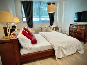 una camera da letto con letto con cuscini rossi e scrivania di Harfa Apartment 30 a Praga