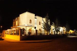 a large white building at night with lights at Apartamentos Rurales Alcazaba de las Torres in Cañete de las Torres