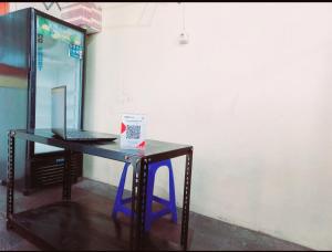 - un bureau avec un ordinateur portable et un tabouret bleu dans l'établissement SPOT ON 91336 Guesthouse Tarumanegara, à Karawang