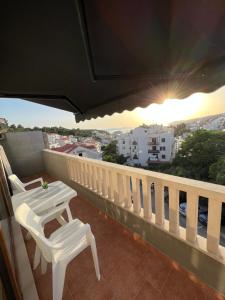 a balcony with two white chairs and a table at Luxury apartman Iris in Hvar