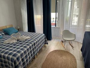 a bedroom with a bed and a chair and windows at Alzira bonita Loft A junto plaza mayor, la Murta in Alzira