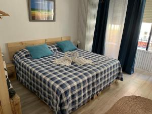 a bedroom with a bed with a blue and white checkered blanket at Alzira bonita Loft A junto plaza mayor, la Murta in Alzira