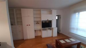 sala de estar con armarios blancos y TV en Apartamento muy acogedor , en el casco antiguo., en Zamora