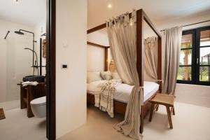 sypialnia z łóżkiem z baldachimem i łazienką w obiekcie Andresita`s Palace State-of-the-art Tropical Villa w mieście Bale +37 zdjęć