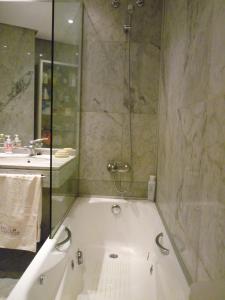 een badkamer met een bad en een douche bij Apartamento muy acogedor , en el casco antiguo. in Zamora