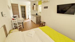a small room with a bed and a kitchen at Apartment PIPO in Krk