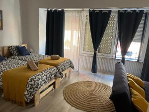 a bedroom with two beds and a large window at Alzira bonita Loft C junto plaza mayor, Les Muralles in Alzira