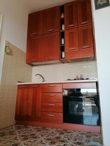 una cucina con armadi in legno e forno a microonde di APPARTAMENTO VISTA MARE a Tropea