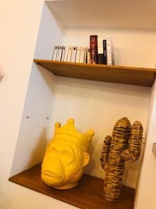 a yellow vase sitting on a shelf with cds at Appartement dans le quartier recherché du mouré in Collioure