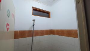 ein Bad mit einer Dusche und einem Fenster an der Wand in der Unterkunft OYO 91341 D'phoenix Anggrek Syariah Residence in Jakarta