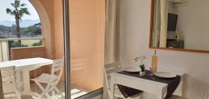 耶尔L'Étoile sous les Pins - La Loge的配有桌子、镜子和桌椅的房间