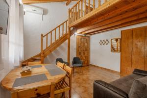a living room with a wooden table and a staircase at Sophia's maisonette 2 in Stoupa