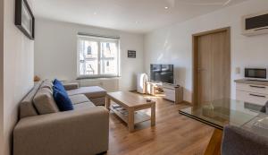 een woonkamer met een bank en een tafel bij Appartement avec RoofTop au centre de Malmedy in Malmedy